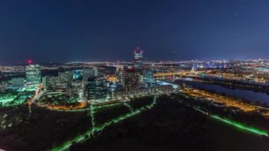 Avusturya 'da gökdelenler, tarihi binalar ve nehir kenarındaki gece gezintisi ile Viyana şehrinin hava panoramik manzarası.