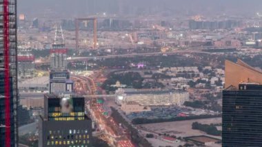 Şehir merkezinden vinçler ile trafik ve inşaat binası ile gece gündüz mali ve zabeel ilçe havadan görünümü