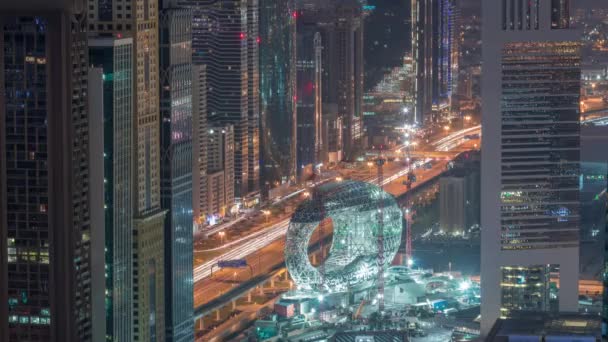 Sitio de construcción del Museo del Futuro noche aérea al día timelapse, próximo edificio icónico de Dubai . — Vídeos de Stock