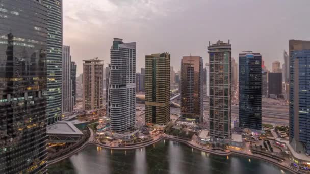 Edificios residenciales y de oficinas en Jumeirah lago torres distrito día a noche timelapse en Dubai — Vídeos de Stock