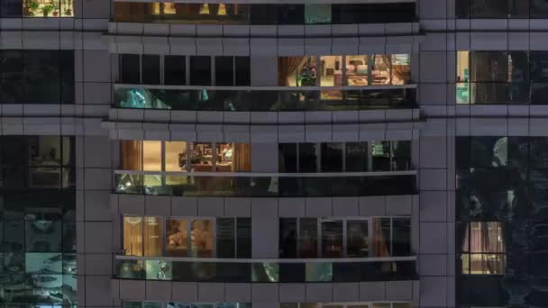 Vista nocturna del apartamento exterior timelapse edificio. Rascacielos de gran altura con luces intermitentes en las ventanas — Vídeos de Stock