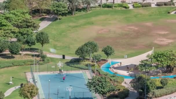 Ein landschaftlich gestalteter öffentlicher park in jumeirah seen türmt sich im zeitraffer auf, ein beliebtes wohnviertel in dubai. — Stockvideo