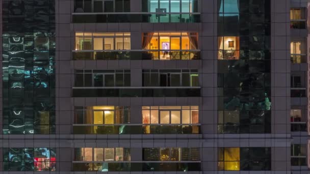 Vue de nuit de l'immeuble d'appartements extérieur timelapse. gratte-ciel de grande hauteur avec des lumières clignotantes dans les fenêtres — Video