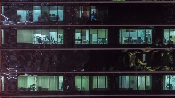 Office skyscraper exterior during late evening with interior lights on and people working inside night timelapse — Stock Video