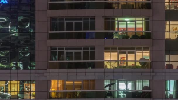 Noční výhled na budovu s vnějším bytem. Vysokorostoucí mrakodrap s blikajícími světly v oknech — Stock video