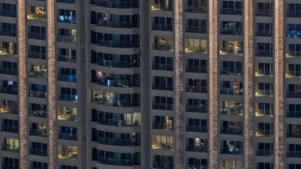 Vista nocturna del timelapse exterior de la torre del apartamento. Rascacielos de gran altura con luces intermitentes en las ventanas — Vídeo de stock