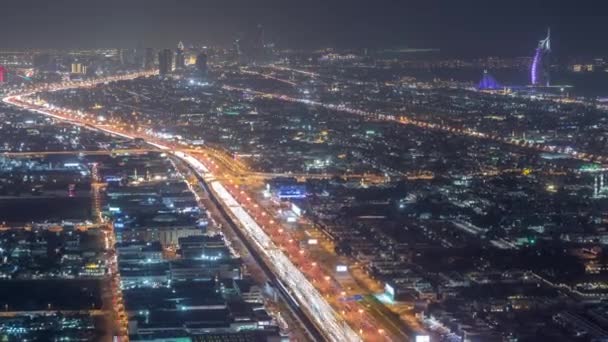 シェイク・ザイード道路と交差点の夜間タイムラプス、ドバイ、アラブ首長国連邦の交通への航空写真 — ストック動画