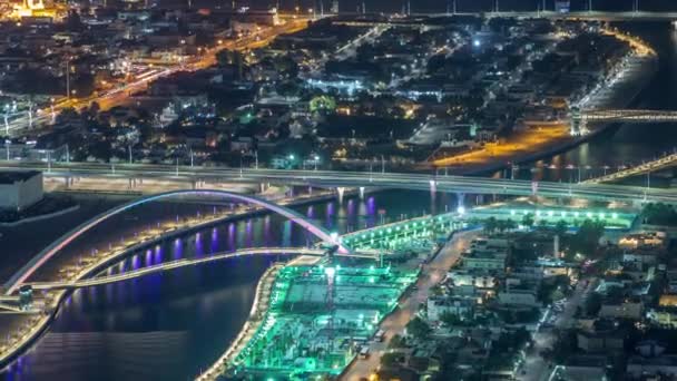 Dubai water canal with footbridge aerial night timelapse from Downtown skyscrapers rooftop — Stock Video