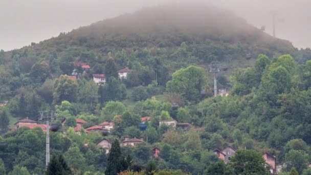 Domy na wzgórzu z kolejką linową poruszającą się w górę iw dół ze stacji Sarajewo do gór, Bośnia i Hercegowina — Wideo stockowe