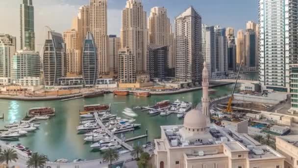 Yates en Dubai Marina flanqueado por la mezquita Al Rahim y torres residenciales y rascacielos timelapse aéreo . — Vídeo de stock