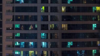 Geceleri apartmanda insanların oturduğu parlak pencereler..