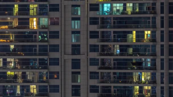 Ряды светящихся окон с людьми в многоквартирном доме ночью . — стоковое видео