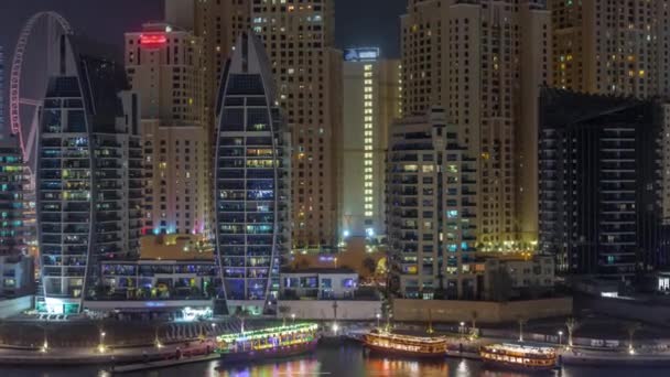 Luxury yachts parked on the pier in Dubai Marina bay with city aerial view night timelapse — Stock Video