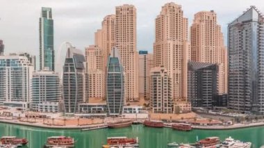 Dubai Marina körfezindeki iskeleye park etmiş lüks yatlar. Şehir havası manzaralı zaman ayarlı.