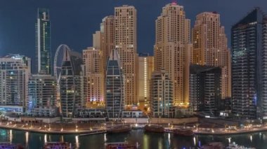 Dubai Marina körfezindeki iskeleye park etmiş lüks yatlar. Gece gündüz havadan izleniyor.
