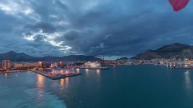 Dalgalı deniz manzarası ve açık denizde yelken açan gemiden liman manzarası.