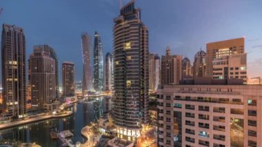Dubai Marina konutlarının ve ofis gökdelenlerinin havadan görüntüsü. Gece gündüz deniz manzaralı.