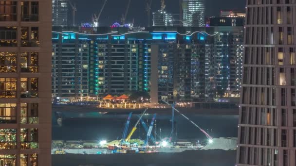 Vista aérea para arranha-céus da marina do Dubai com canteiro de obras e Palm Jumeirah Island na timelapse da noite de fundo . — Vídeo de Stock