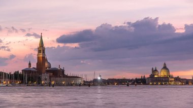 Canal Grande ve Basilica Santa Maria della Salute gemilerde, San Giorgio Maggiore Adası gün gece için geçiş timelapse, Venezia, Venedik, İtalya. Renkli bulutlu gökyüzü. Akşam aydınlatma