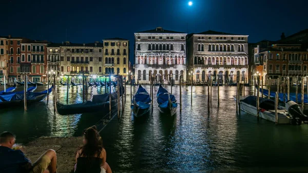 The magnificent Palazzo Balbi overlooking the Grand Canal in Venice night timelapse. People sitting and gondolas on foreground. Now home to the President and local government of the Veneto region of Italy.