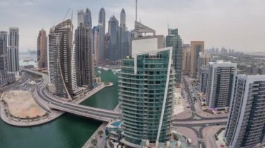 Dubai Marina yerleşim yerlerinin ve ofis gökdelenlerinin havadan görüntüsü. Rıhtıma bakan gündüz ve gece saatleri var.