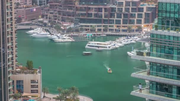 Vista aérea de los rascacielos residenciales y de oficinas de Dubai Marina con timelapse de día a noche frente al mar — Vídeos de Stock