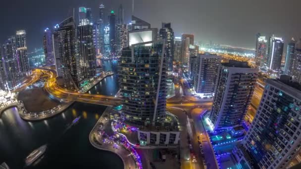 Vista aérea de los rascacielos residenciales y de oficinas de Dubai Marina con timelapse nocturno frente al mar — Vídeos de Stock