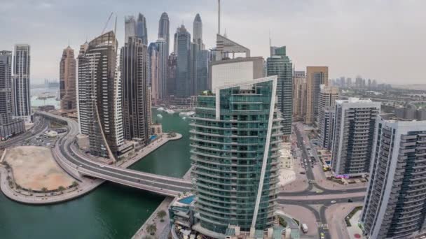 Vista aérea de los rascacielos residenciales y de oficinas de Dubai Marina con timelapse de día a noche frente al mar — Vídeos de Stock