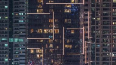 Geceleri apartmanda insanların oturduğu parlak pencereler..