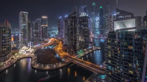 Vista aérea dos arranha-céus residenciais e de escritório da Marina do Dubai com a timelapse da noite à beira-mar — Vídeo de Stock