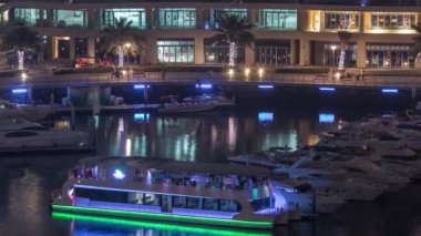Dubai Marina Limanı 'ndaki rıhtım güvertesi gece uçuşları. Dubai, Birleşik Arap Emirlikleri