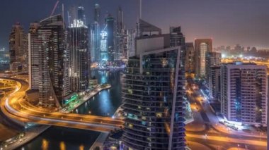 Dubai Marina konutlarının ve ofis gökdelenlerinin havadan görüntüsü. Gece gündüz deniz manzaralı.
