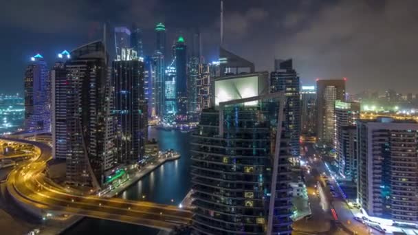 Vista aérea de los rascacielos residenciales y de oficinas de Dubai Marina con hiperlapso del timelapse nocturno frente al mar — Vídeos de Stock