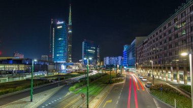Milan Porta Nuova iş ilçe gece timelapse, Milano, İtalya içinde modern gökdelenler ile manzarası. Yolda trafik. Işık içinde pencere eşiği. Köprüsü'nden Üstten Görünüm