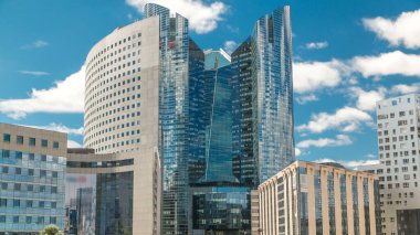 Savunma timelapse modern iş ve Finans Merkezi Paris'te highrise binaları ile gökdelenler. Grande Arche görünümden. Yaz günü mavi bulutlu gökyüzü. Modern kuleleri yansımalar.