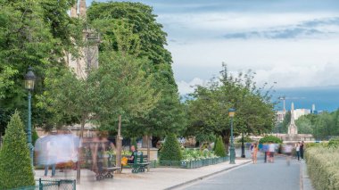 Notre Dame de Paris Garden, Cite Island 'da, Paris, Fransa. İnsanlar yeşil ağaçlar ve çiçeklerle parkta yürüyor. Yaz gününde bulutlu bir gökyüzü