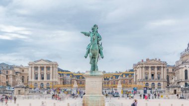 14. Louis Zaman Geçidi 'nin binicilik heykeliyle Versailles Kalesi' nin geçit töreni. Trafik vardı ve turistler dolaşıyordu. Yaz gününde bulutlu bir gökyüzü