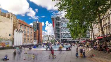 Centre Pompidou 'daki Çeşme, Ulusal Modern Sanat Müzesi. Paris, Fransa. İnsanlar yaz günü mavi bulutlu gökyüzü ile meydanda dinleniyorlar.