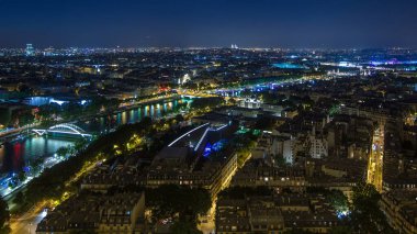 Paris Şehri ve Seine Nehri 'nin, Eyfel Kulesi gözlem güvertesinin tepesinde çekildiği Hava Gecesi zaman çizelgesi. Akşam aydınlatması. Yollarda trafik