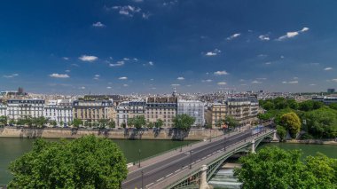 Paris timelapse ve Sully Köprüsü üzerinde trafik ile Panoraması. Arap Dünya Enstitüsü (Institut du Monde Arabe) bina gözlem güverteden görüntüleyin. En iyi hava görünümünü. Yeşil ağaçlar, Seine Nehri, yaz günü bulutlu gökyüzü mavi. Fransa.
