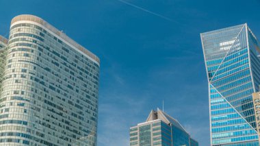 Paris 'in ünlü finans ve iş bölgesi La Defense' da modern gökdelenler zaman çizelgesi. Mavi bulutlu bir camda yansımalar ve yaz günü mavi gökyüzü.