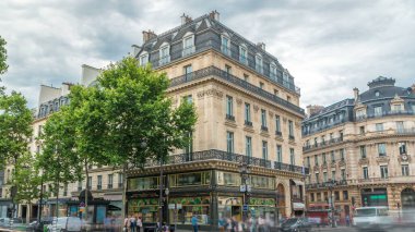 Opera kare timelapse trafik ile. (Charles Garnier tarafından tasarlanmış) Opera Garnier, Paris, Fransa'da oturtulmuş aynı zamanda inşa edildi. Yaz günü bulutlu gökyüzü