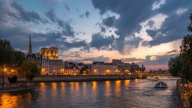 İnsanlar tekneler gün ve gece geçiş timelapse Notre Dame de Paris, Le Pont D'Arcole köprüden sonra günbatımı, Paris, Fransa, Europe ile. Yaz günü Seine nehrinde yansıması ile renkli gökyüzü. Tilt-shift objektif