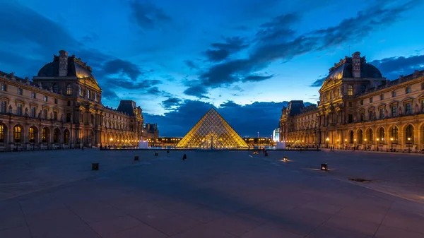 フランスで日没から夜への移行時間経過後のルーヴル美術館のピラミッド 夏の日にカラフルな空 広場を歩く人々 — ストック写真