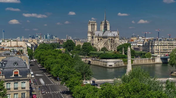 Paris Panorama with Cite Island and Cathedral Notre Dame de Paris on the background timelapse from the Arab World Institute observation deck. Top view. Green trees, Seine river, Blue cloudy sky at summer day. France.