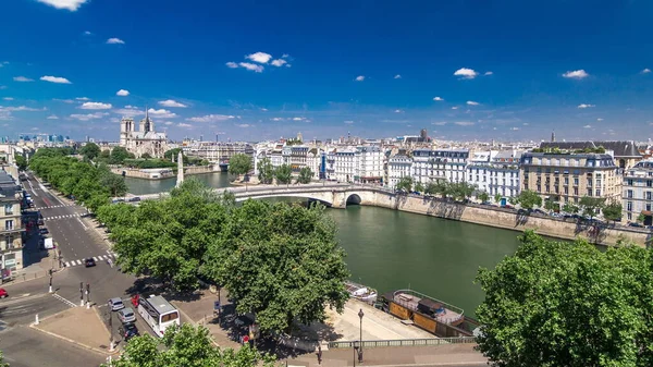 Paris Panorama with Cite Island and Cathedral Notre Dame de Paris on the background timelapse from the Arab World Institute observation deck. Top view. Green trees, Seine river, Blue cloudy sky at summer day. France.