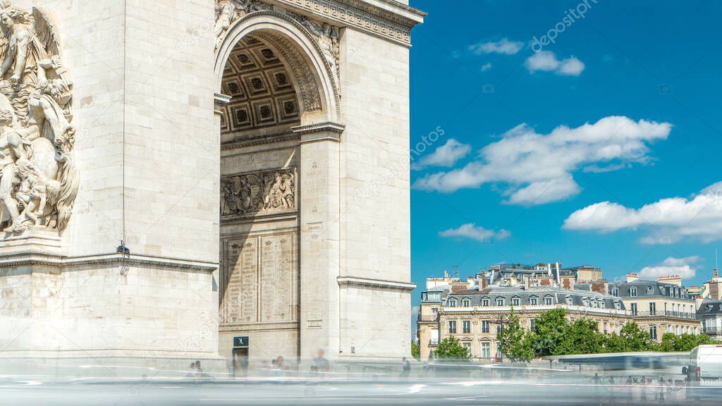 The Arc de Triomphe (Triumphal Arch of the Star) timelapse is one of the most famous monuments in Paris, standing at the western end of the Champs-Elyseees. Traffic on circle road. Blue cloudy sky at summer day