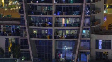 Geceleri apartmanda insanların oturduğu parlak pencereler..