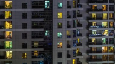 Geceleri apartmanda insanların oturduğu parlak pencereler..