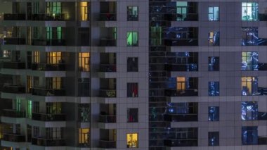 Geceleri apartmanda insanların oturduğu parlak pencereler..